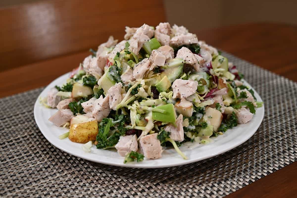 Costco Eat Smart Sweet Kale Salad Kit on a plate with added chicken, pear, avocado. 