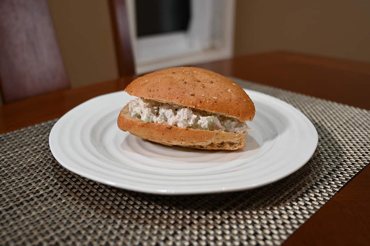 Image of a prepared triangle shaped chicken salad sandwich on a white plate.