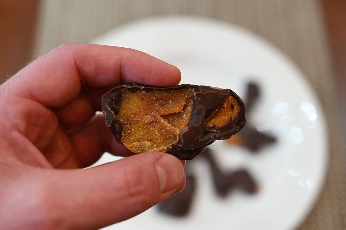 Close up image of one Costco Kirkland Signature Chocolate Covered Mango with a bite taken out.
