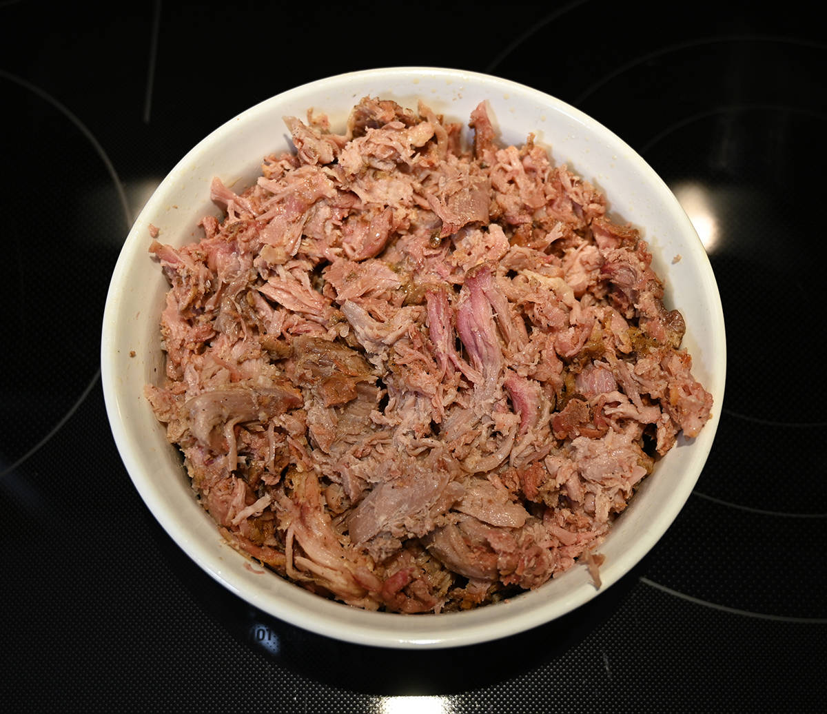 Top down image of the cooked pulled pork in a casserole dish.