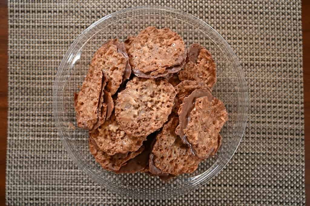 Image of Costco Desserts on Us Laceys  Macadamia Milk Chocolate Cookie Container open and sitting on a placemat so you can see the cookies 