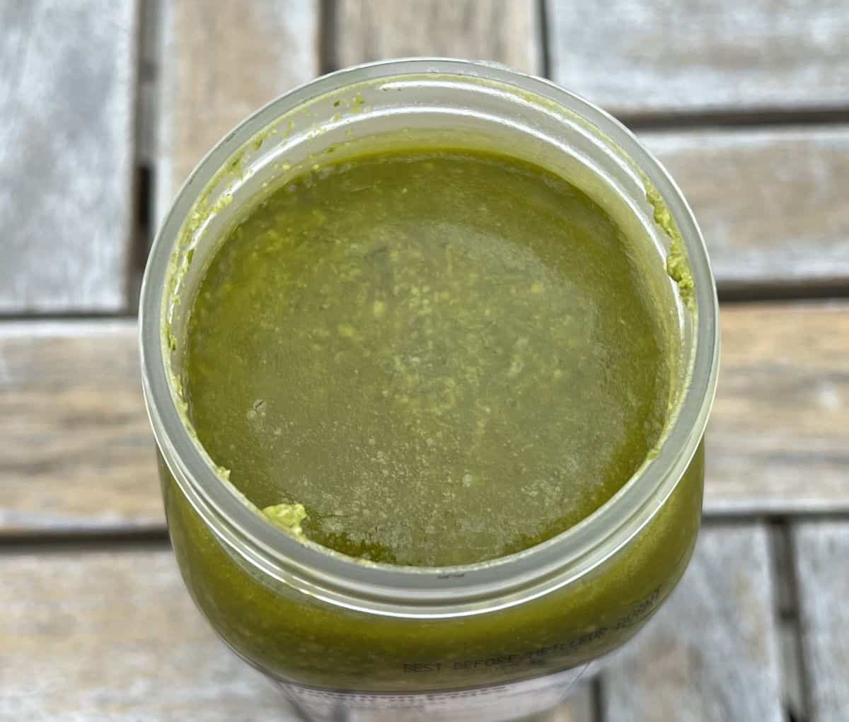 Image of an open jar Kirkland Signature Basil Pesto prior to being stirred.