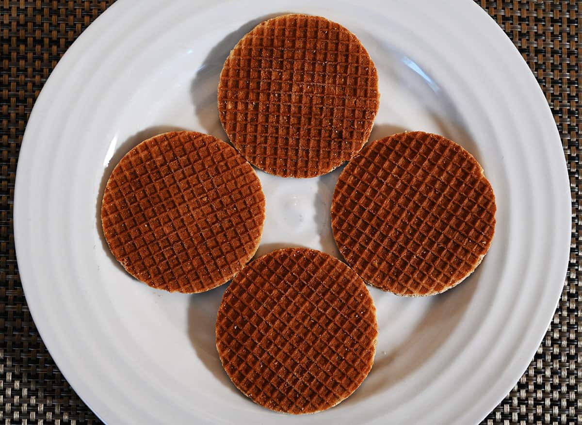 Top down image of four stroopwafel cookies served on a white plate.