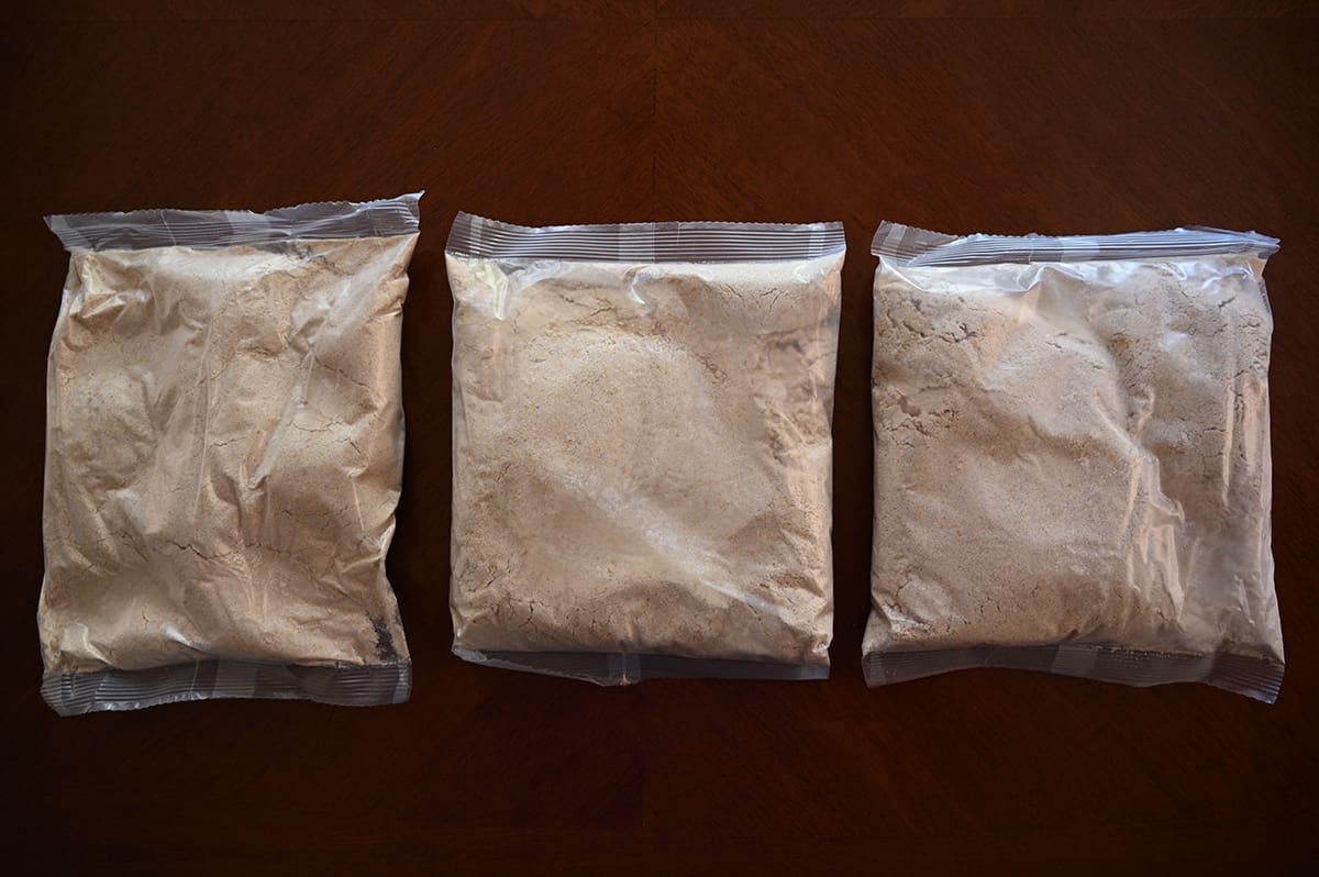 Top down image showing three unopened bags of quick bread mix sitting on a table.