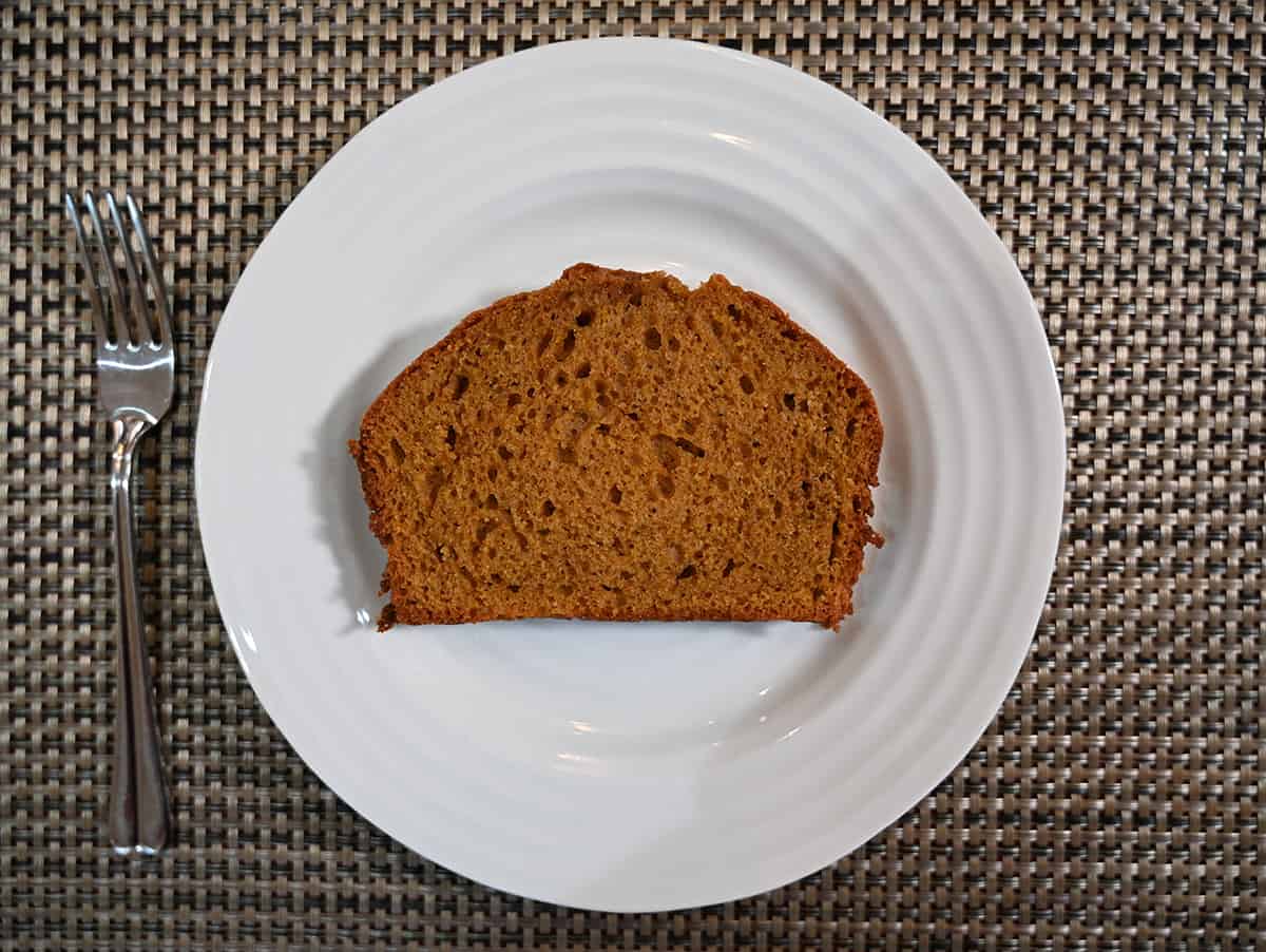 Top down image of one slice of pumpkin spice loaf served on a white plate.