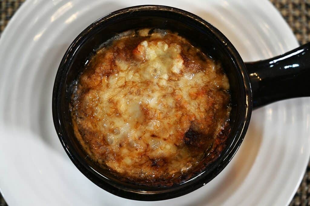 Costco Cuisine Adventures French Onion Soup prepared in a bowl, closeup image of the top baked cheese. 