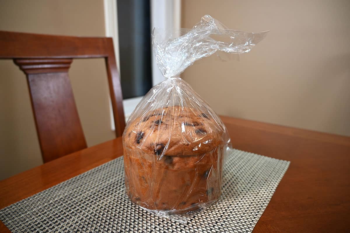 Image of the panettone sitting on a table still in the plastic wrapping.