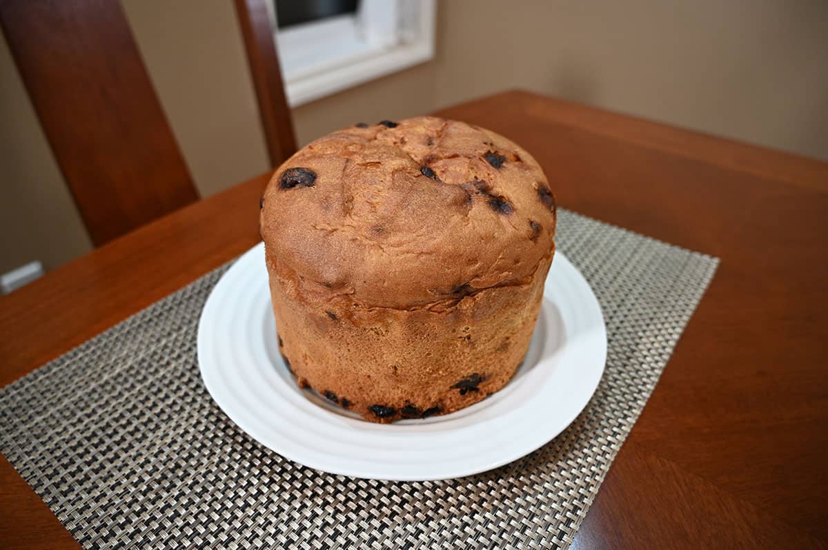 Image of the entire panettone removed from the packaging and sitting on a white plate.