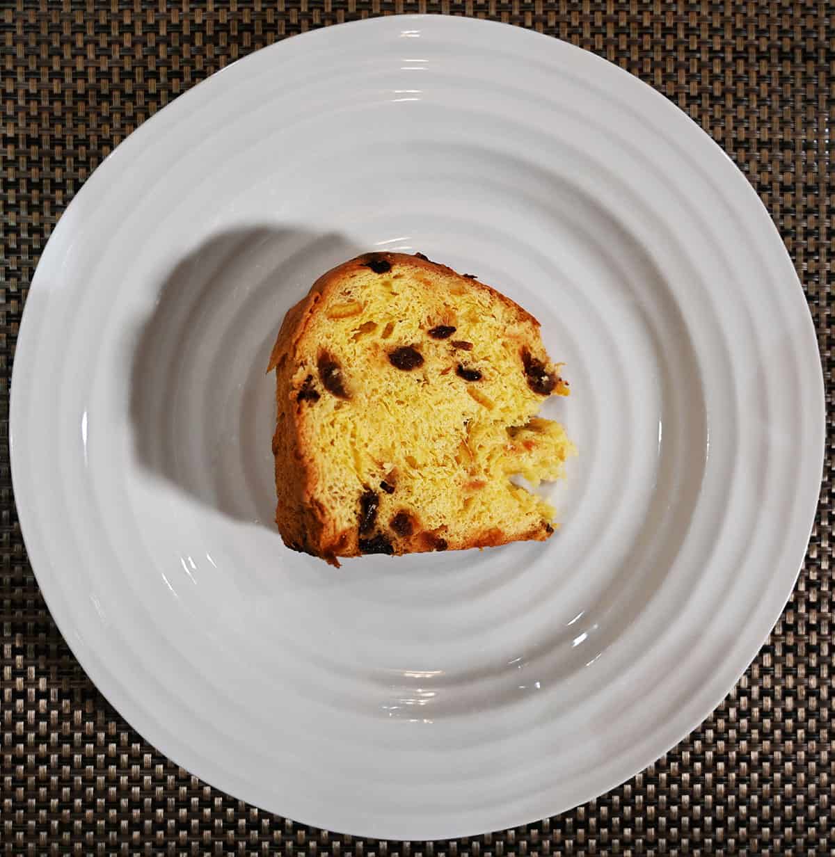 Top down image of one slice of panettone served on a white plate.