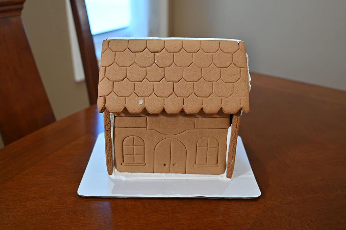 Image of the gingerbread mansion unwrapped and sitting on a piece of cardboard, ready to decorate.