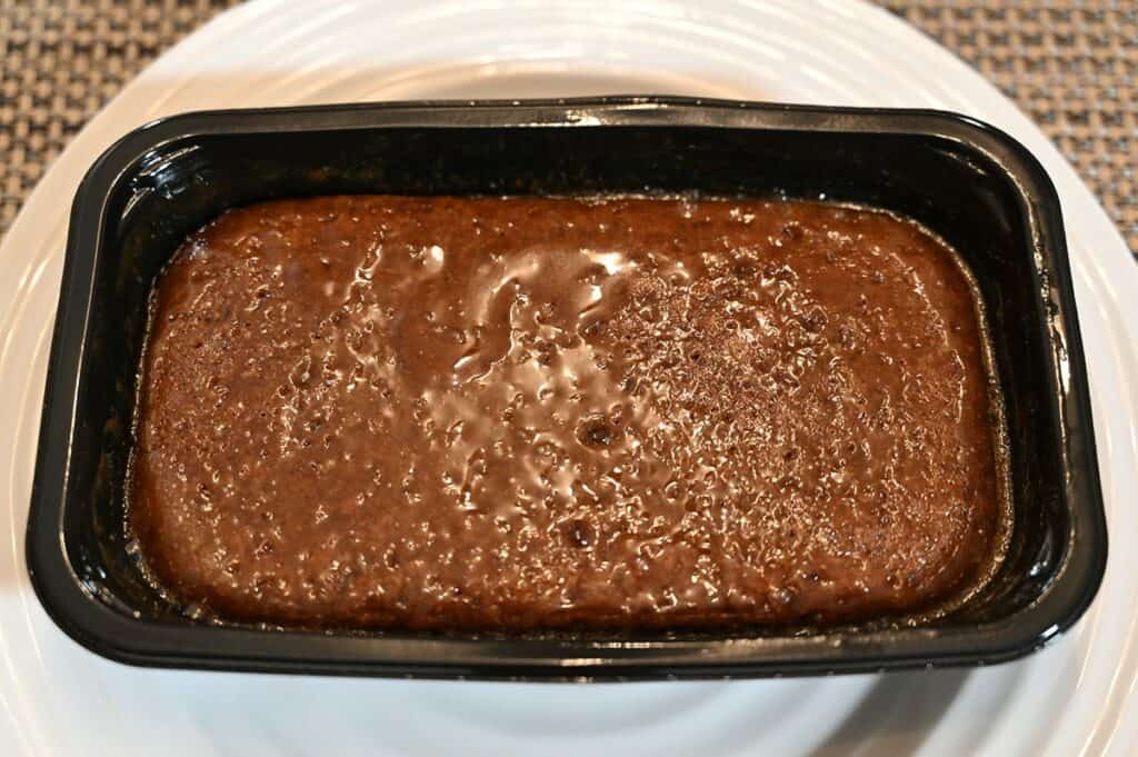 Top down image of the Costco The Sticky Toffee Pudding Co. Sticky Toffee Pudding baked and in the tray, sitting on a plate. 
