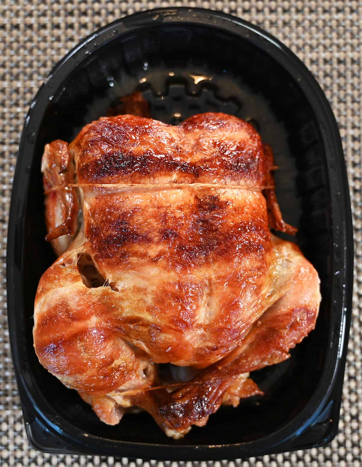 Top down image of the full chicken sitting in the tray with the lid off.