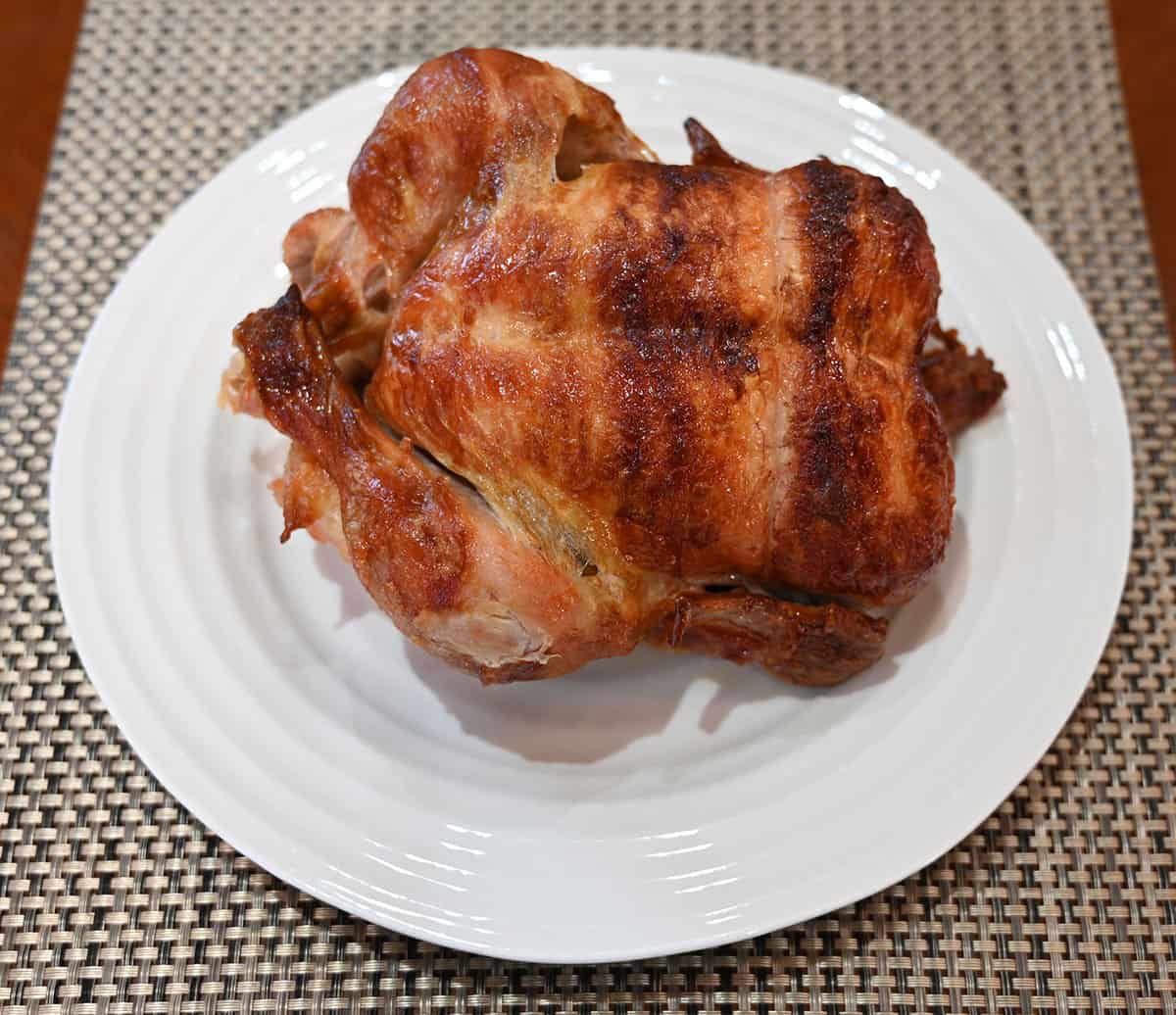 Image of the rotisserie chicken out of the tray and sitting on a white plate.