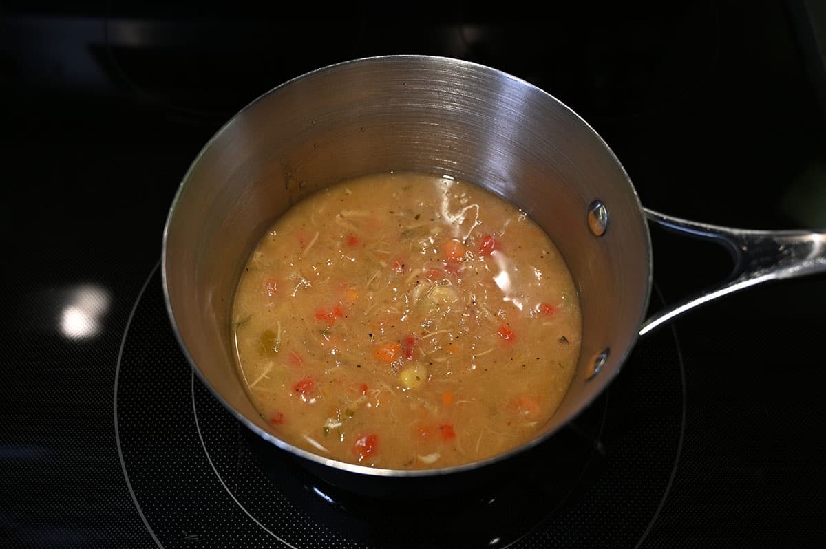 Image of a saucepan on the stove full of chicken tortilla soup simmering.