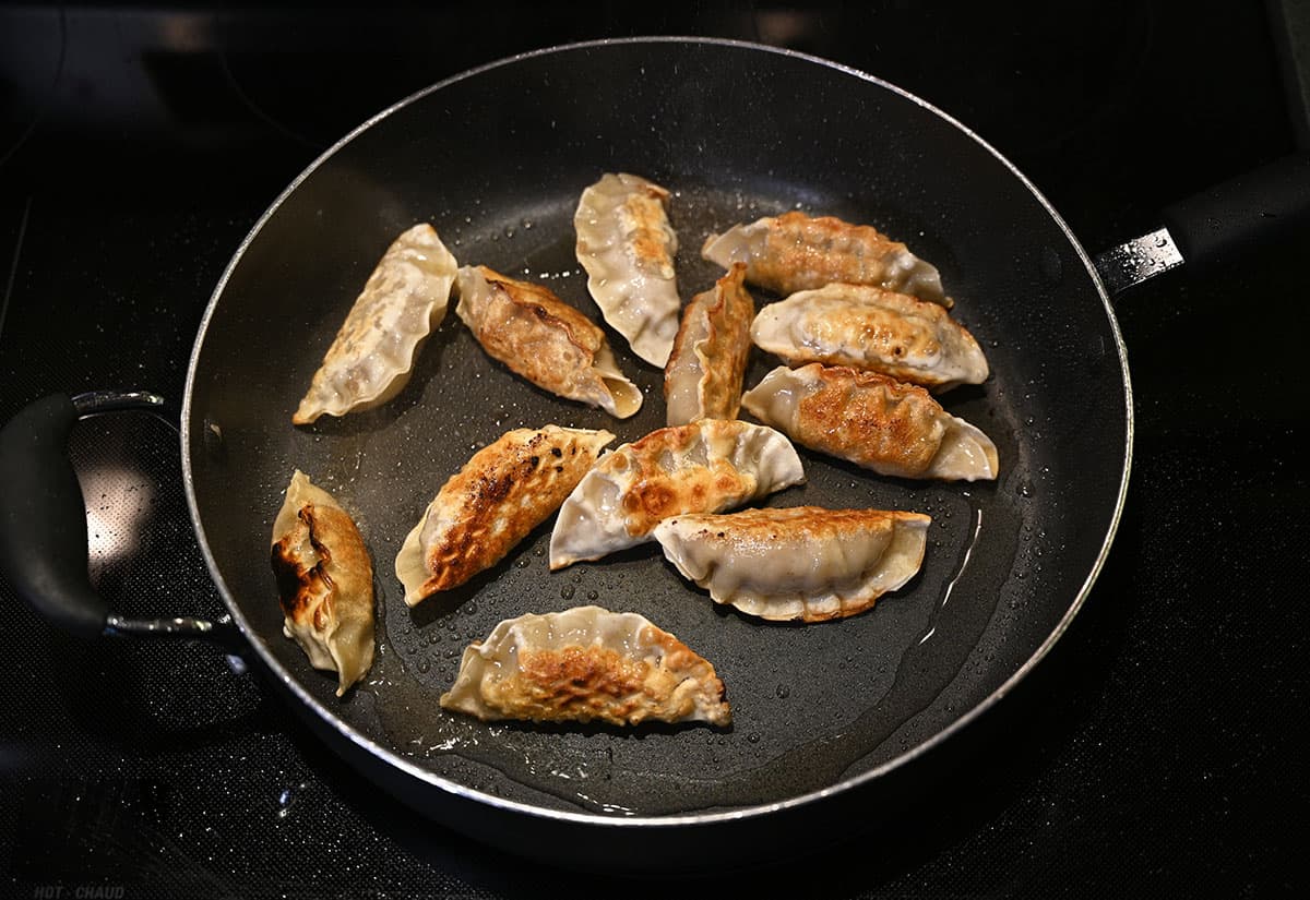 Cooked beef mandu in a fry pan, top down image.