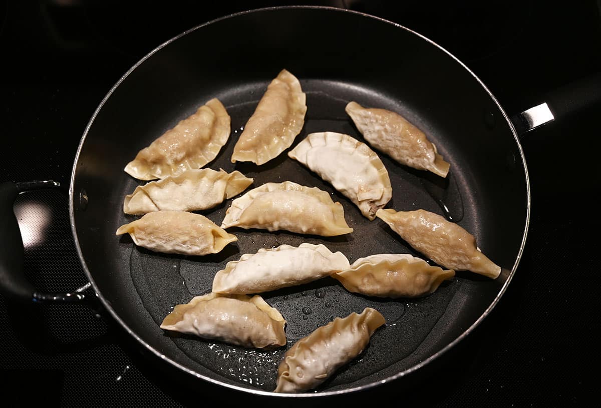 Frozen Costco Bibigo Beef Bulgogi Mandu in a fry pan before cooking.