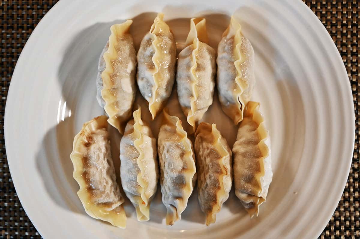 Nine frozen Costco Bibigo Beef Bulgogi Mandu on a white plate.