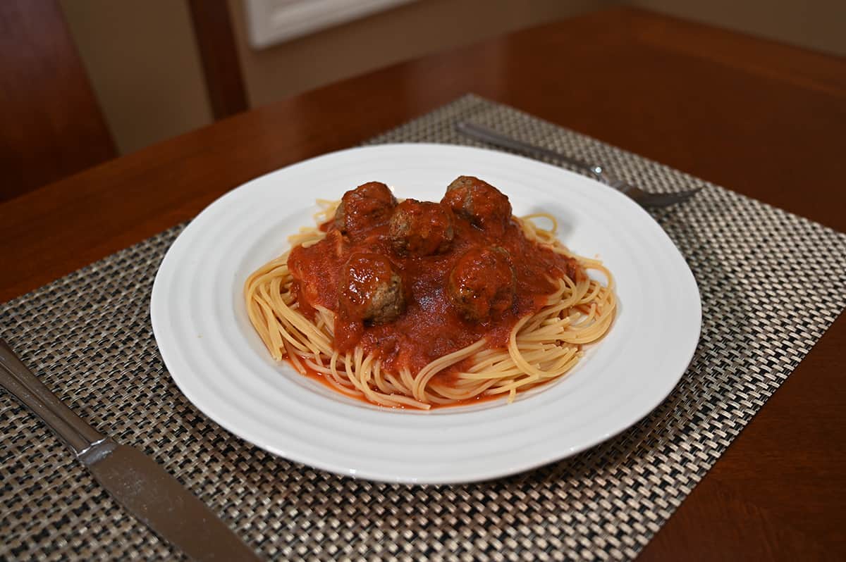 Image of a plate of spaghetti and meatballs sitting on a table.
