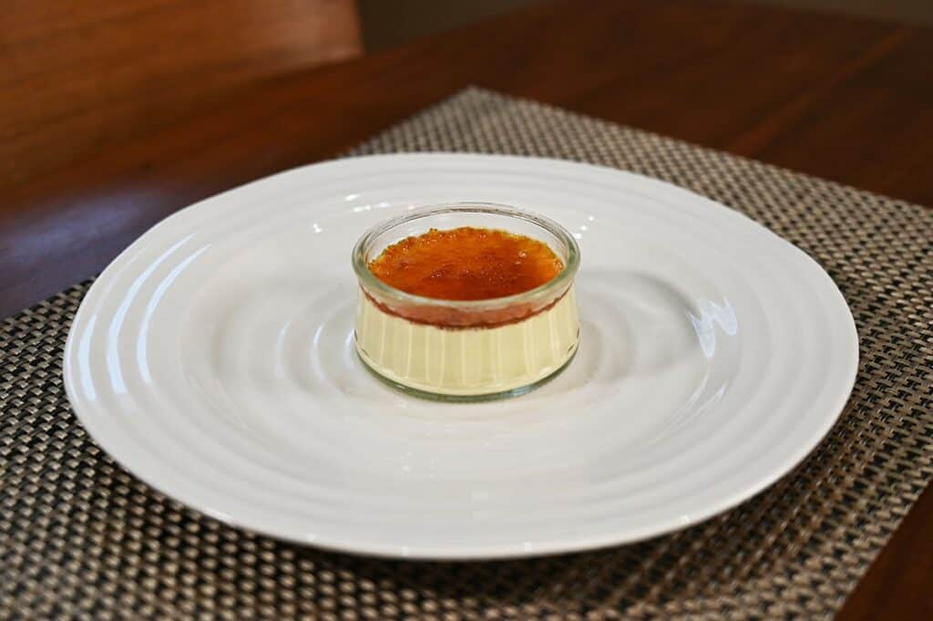 One Costco Marie Morin Crème Brûlée prepared with caramelized sugar on top, served on a white plate. 