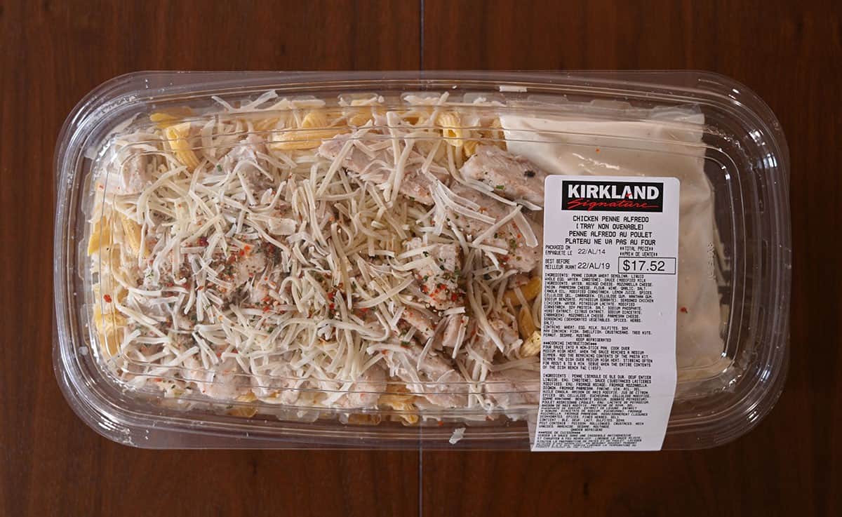 Costco Kirkland Signature Chicken Penne Alfredo tray sitting on a table, top down image. 