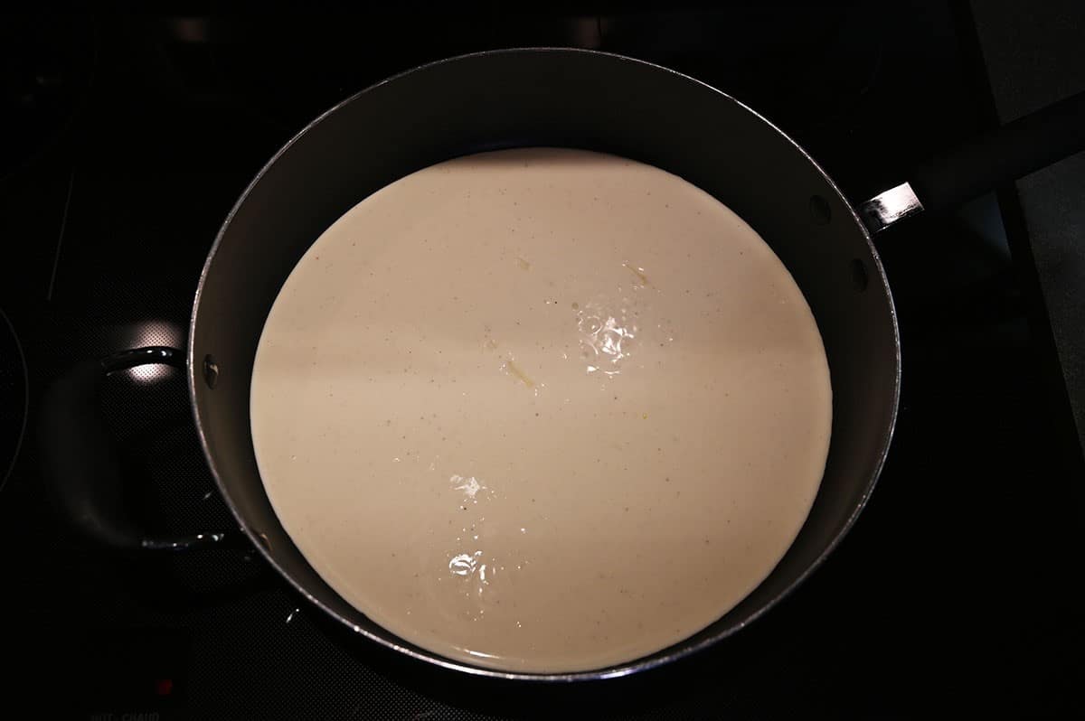 Image of Costco Kirkland Signature Chicken Penne Alfredo sauce cooking in a pan by itself. 