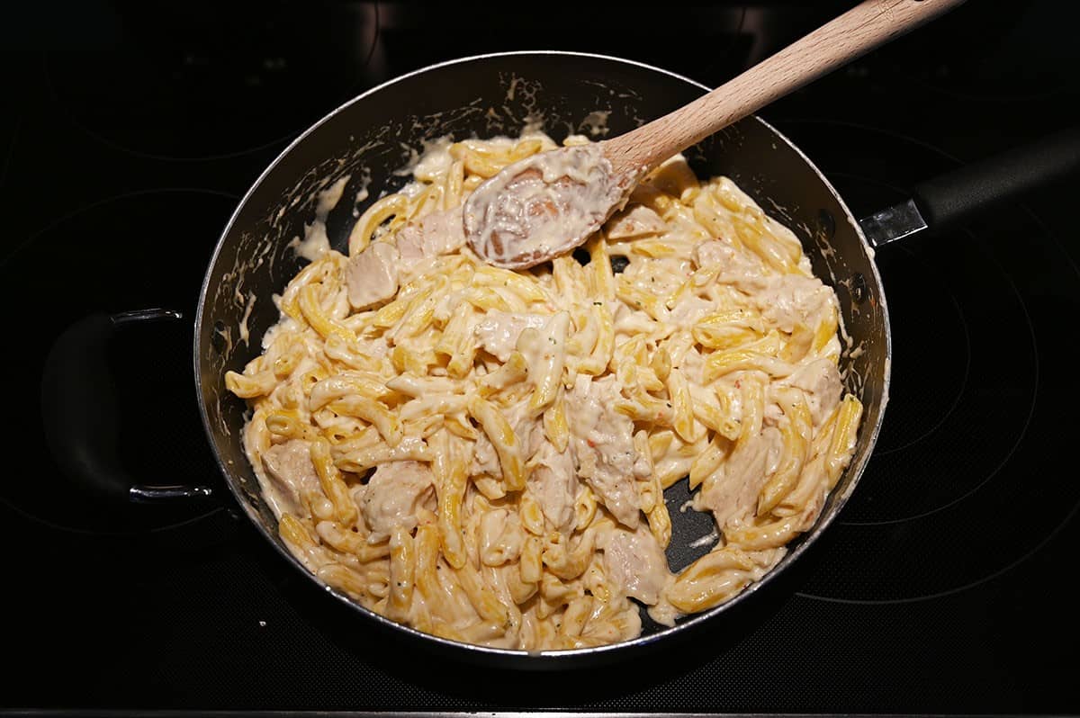 Image of the chicken penne alfredo being cooked in a pan. 