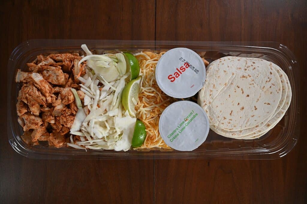 Costco Kirkland Signature Chicken Tacos sitting on a table with the lid off the package so you can see the contest. 