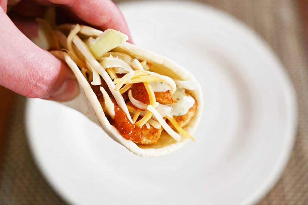 Costco Kirkland Signature Chicken Taco closeup image of one taco made with all the ingredients and folded