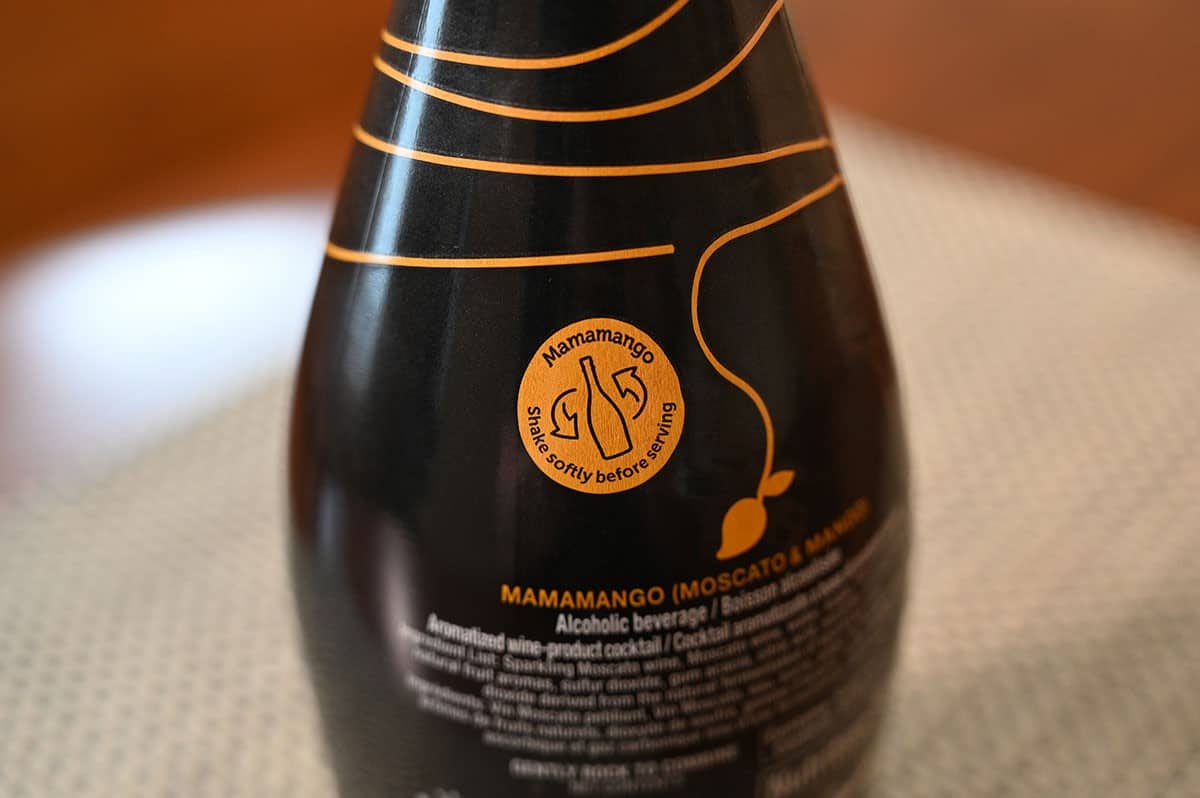 The back of the Costco Mamamango Mango Moscato bottle that says to shake it gently. 