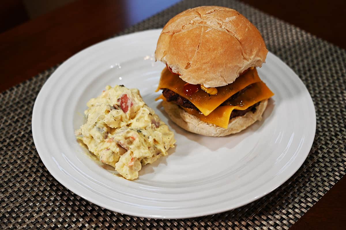 Costco Stonemill Kitchens Homestyle Red Potato Salad served beside a hamburger on a white plate. 