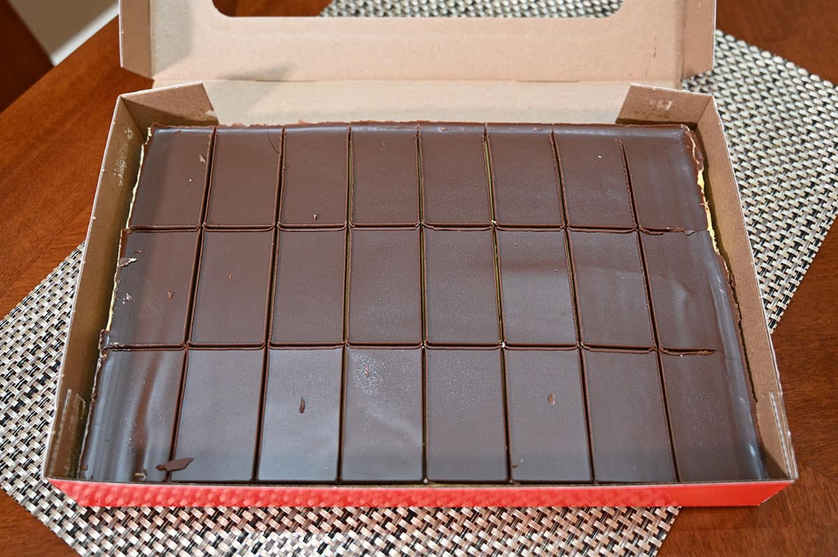 Top down image of the box of Nanaimo bars with the lid open, box is sitting on a table.