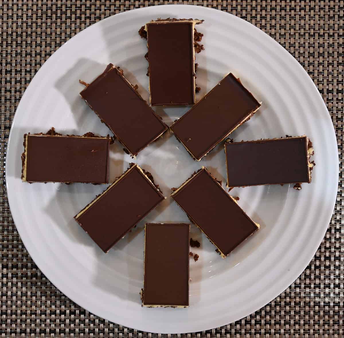 Top down image of the Nanaimo bars cut and served on a white plate.