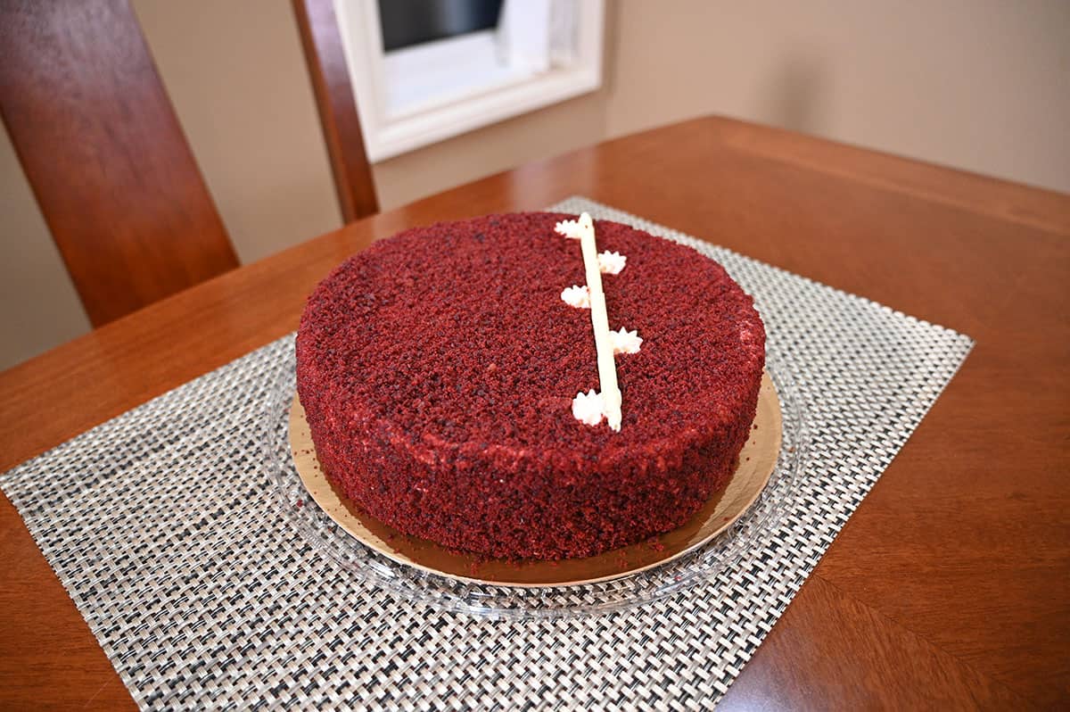 Image of the red velvet cheesecake sitting on a table with the lid off so you can see the cake. 