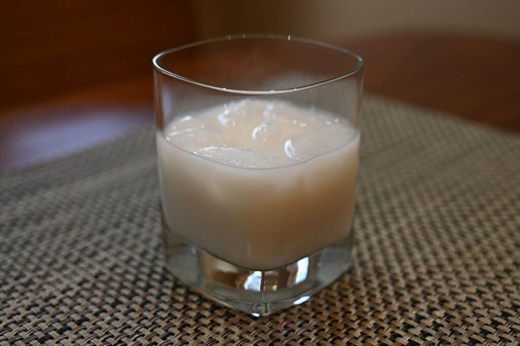 Image of the Costco Kirkland Signature Traditional Holiday Egg Nog in a glass with ice in it