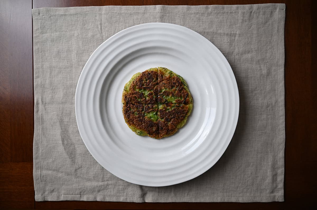 Top down image of one pancake cooked and served on a white plate.