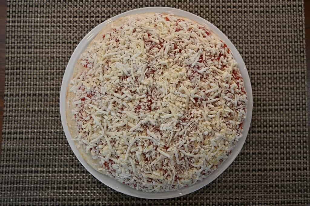 Image of the Costco Kirkland Signature Frozen Cheese Pizza unwrapped and befote baking 