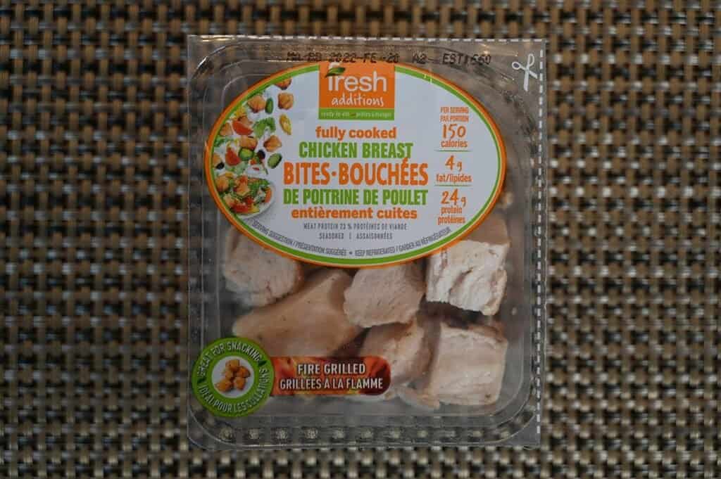 Costco Fresh Additions Fully Cooked Chicken Breast Bites single package sitting on a placement, top down image. 
