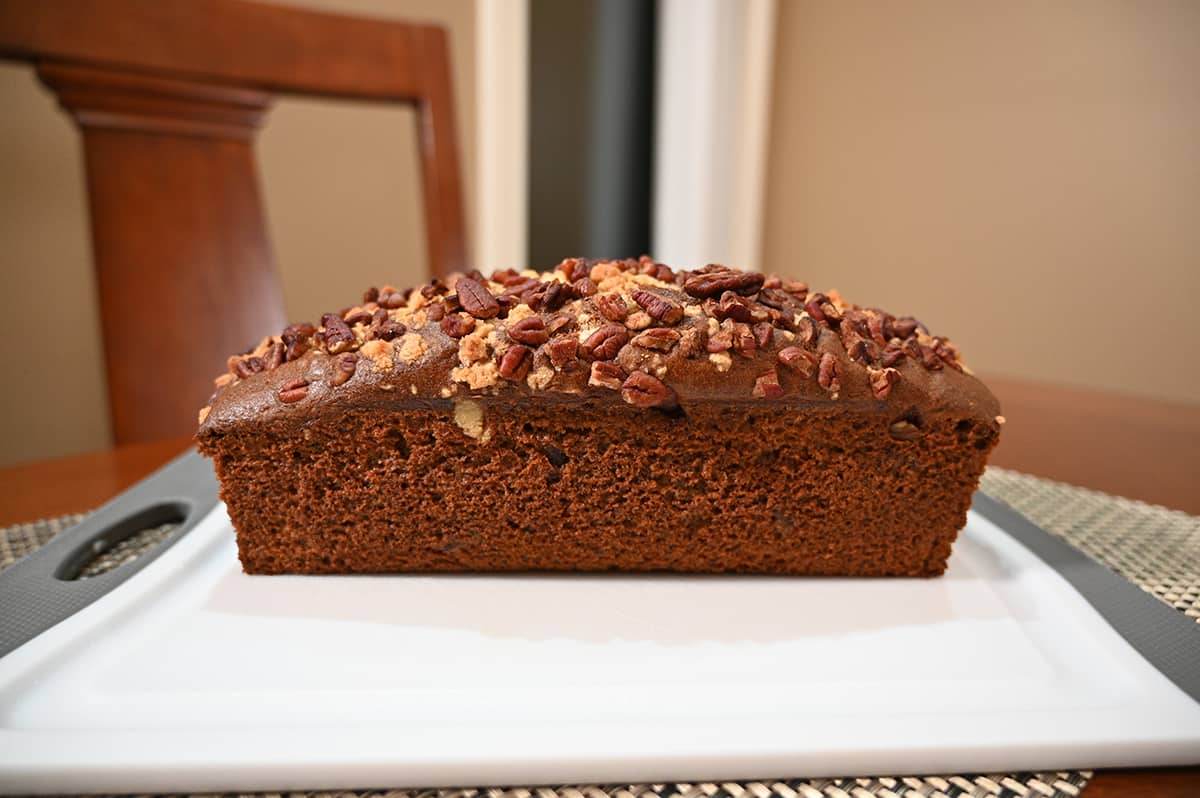 Side view image of the banana pecan loaf out of the packaging and sitting on a cutting board.