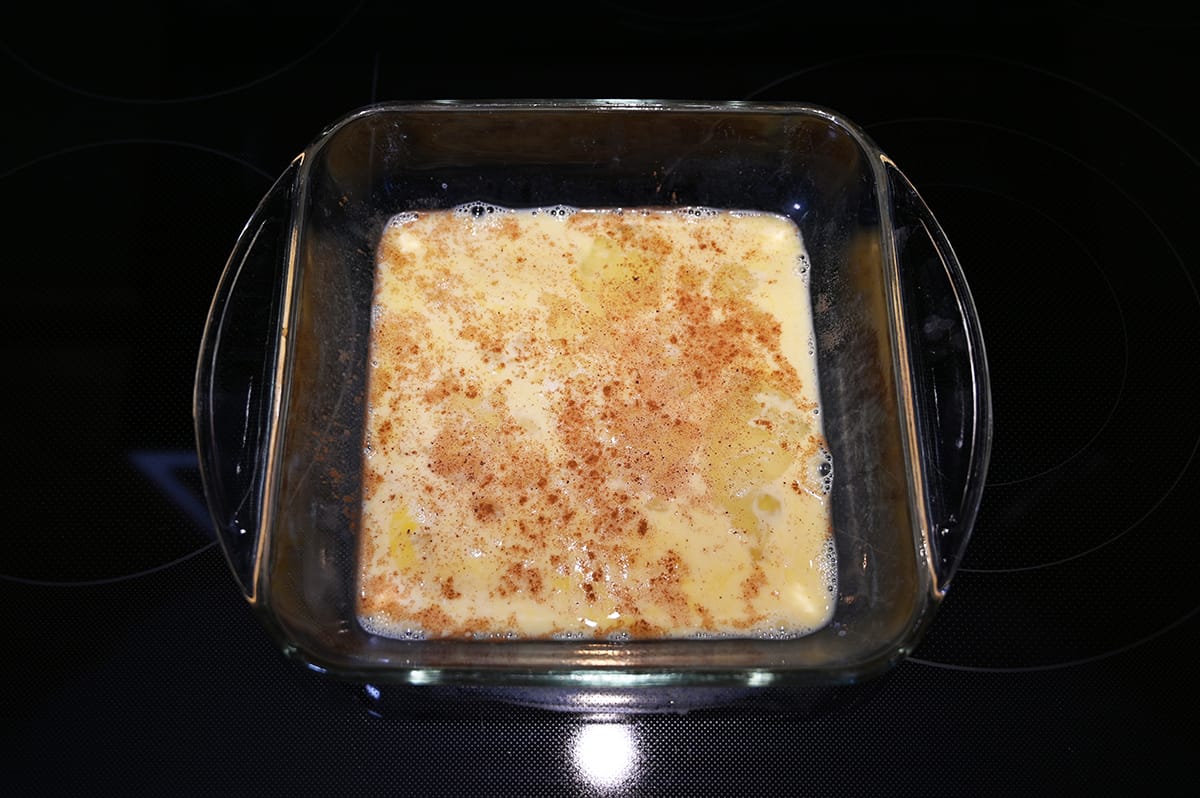Top down image of the banana bread french toast mixture of eggs and milk in a shallow dish.