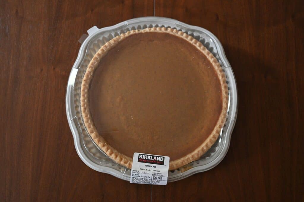 The Costco Kirkland Signature Pumpkin Pie in its plastic container.