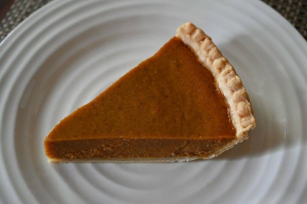 A slice of Costco Pumpkin Pie on top on a plate.