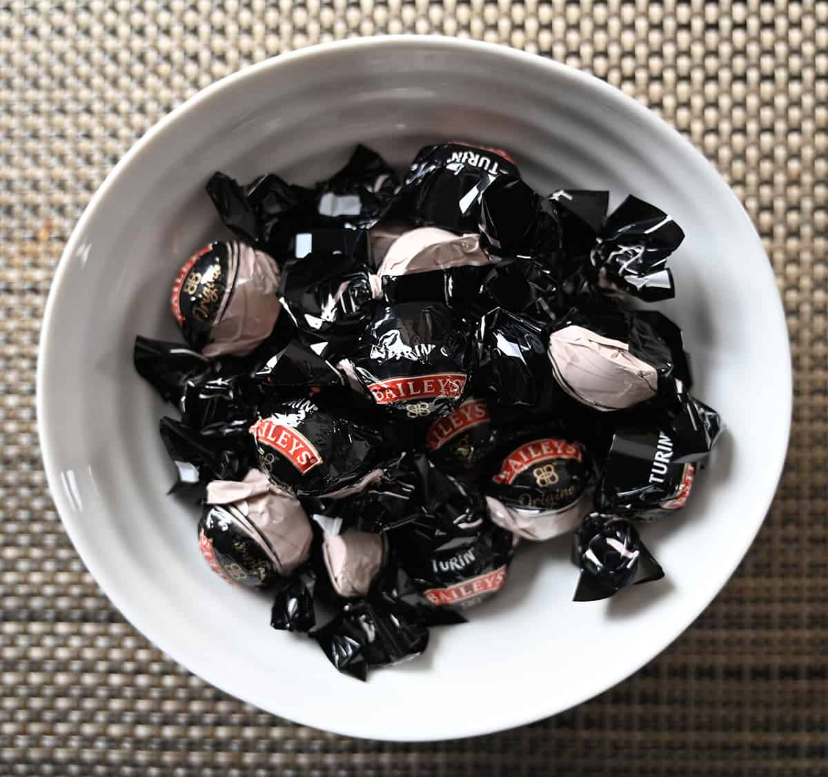 Top down image of a bowl of Baileys chocolates in their wrappers.