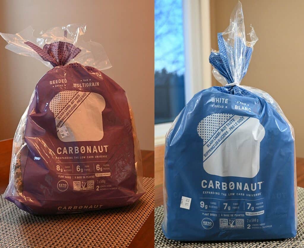 Image of the two bags of Costco low carb Carbonaut bread side by side on a table one bag is multigrain and one is white bread
