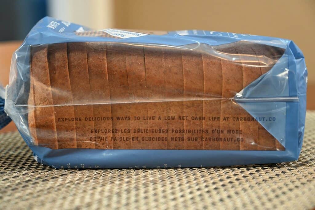Image of the Carbonaut White Bread loaf of bread with a view of the side of the bag that says "explore delicious ways to a live a low net carb life at carbonaut.com".