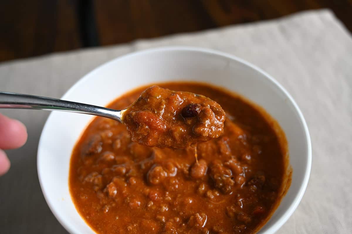 Top down image of a bowl of chili with a spoon scooping some out of the bowl.