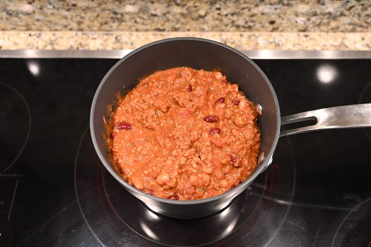 Top down image of a pot of chili being heated on the stove.