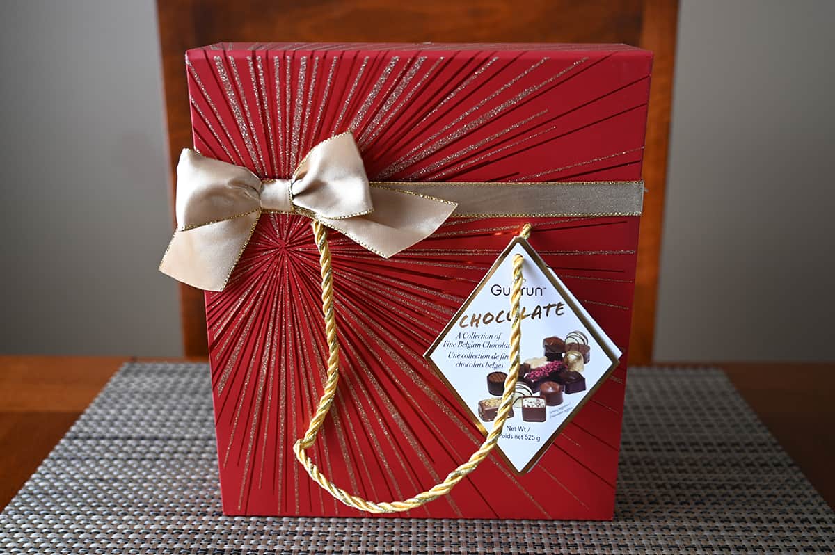 Image of the Costco Gudrun Fine Belgian Chocolates box sitting on a table unopened in a gift bag.