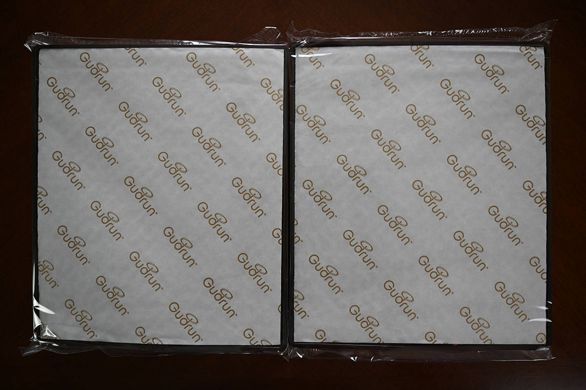 Top down image of two trays of chocolates from the box wrapped in plastic.