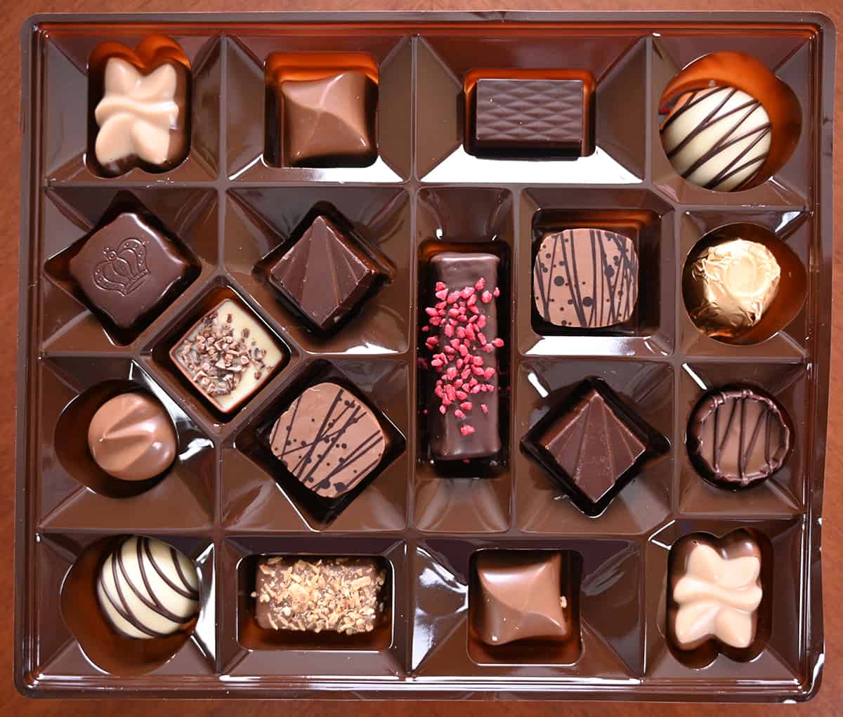Top down image of an open box of Gudrun chocolates unwrapped so you can see all the different chocolates.