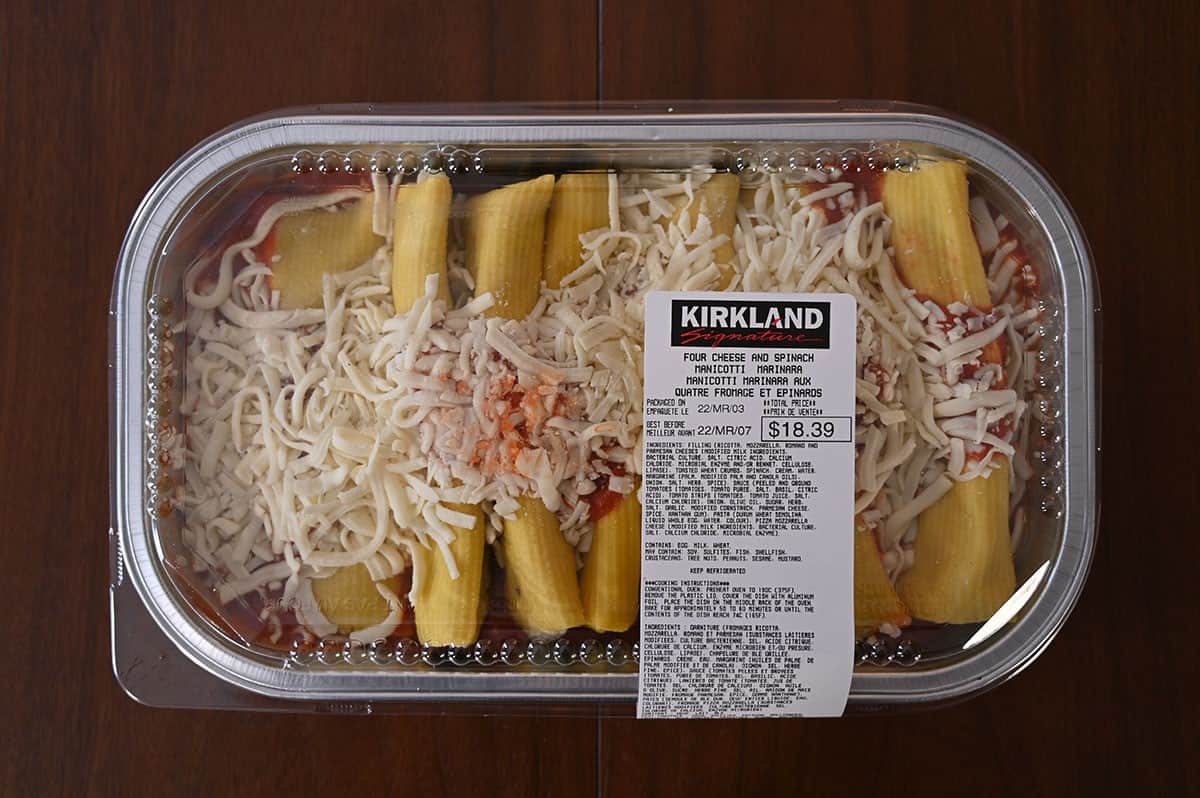 Top down image of the Costco Kirkland Signature Four Cheese and Spinach Manicotti tray on a wood table. 